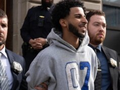 Suspeito sorridente algemado após suposta tomada de controle de rua, corrida de arrancada capturada pela câmera