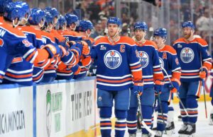 Uma mulher sentada em Rogers Place durante a partida dos Oilers