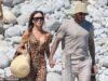 Victoria Beckham mostra uma sugestão de seu biquíni dourado que ela aconchega ao marido David enquanto leva Romeo, Harper e Kim Turnbull em uma viagem de iate em Ibiza