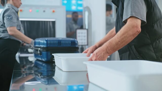 man-picks-up-empty-bin-airport-security.jpg
