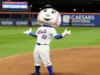 Repórter do Mets disseca a temporada miserável do time enquanto Pleasure Evening Mr. Met dança atrás dele