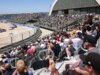 Fan pula cerca durante corrida da NASCAR com bandeira vermelha na Base Naval Coronado de San Diego para encontrar um piloto